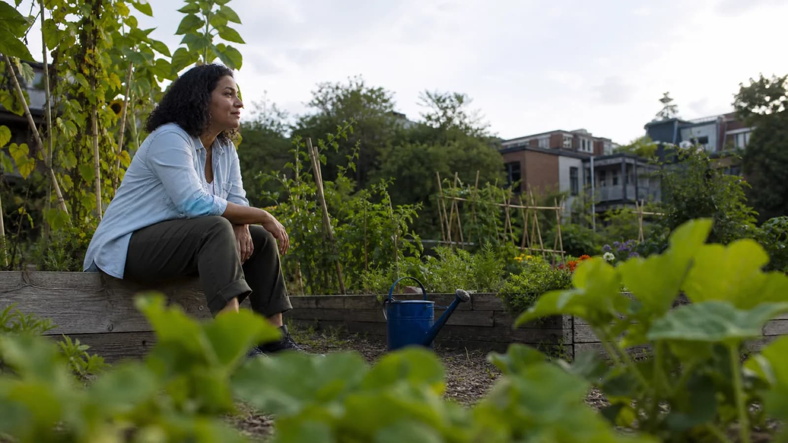 A woman in her forties takes a short break in a Montréal community garden.